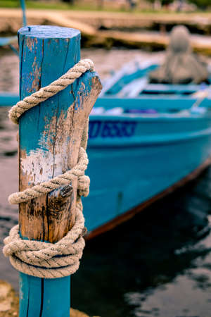 A blue boat sitting on top of a wooden fenceの写真素材