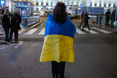 A woman with a yellow and blue flag of Ukraine in Berlin.