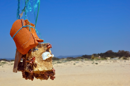 Abstract sculpture or totem made of stone, crocks and seashells in the ocean shore, summer, Tavira, Portugalの写真素材