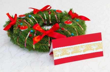 Classical Christmas wreath with red candles and card on the tableclothの写真素材
