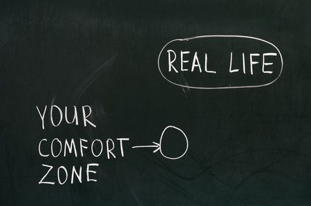 Blackboard concept for leaving your comfort zone behind and moving in to the real lifeの写真素材