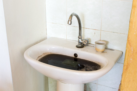 Old dirty ant clogged sink in bathroomの写真素材