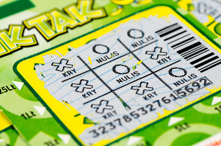 Lottery scratch ticket being played in hopes of winning a cash prizeの写真素材