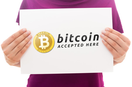 Girl holding white paper sheet with Bitcoin logoの写真素材