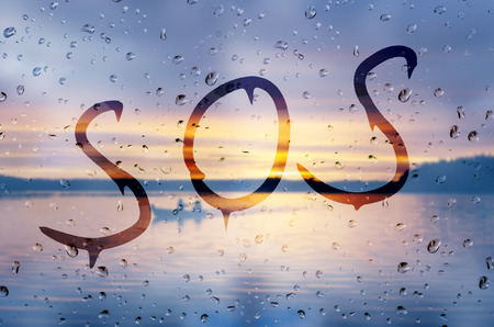 Rain on glass with SOS textの写真素材