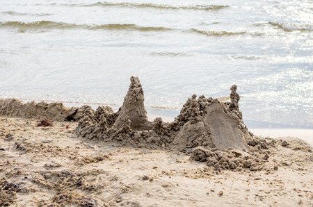 Sandcastle in the making on a sunny beachの写真素材
