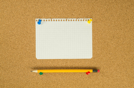 Note paper on cork board with pencil