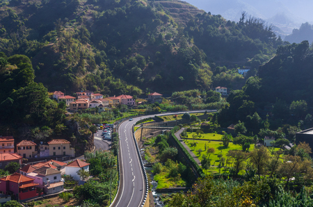 Sao Vicente; Madeira; Portugal - October 30; 2019: The main street, chanal and houses by the mountain.のeditorial素材