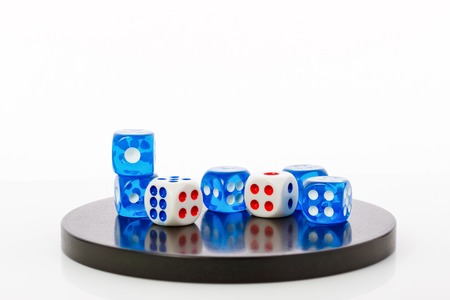 few blue and white dices on a round stone base