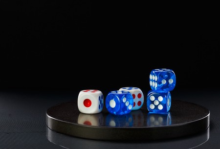 few blue and white dices on a round stone baseの写真素材