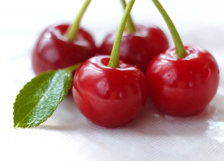 sweet red cherry berry with green leaf on white background. selective focus