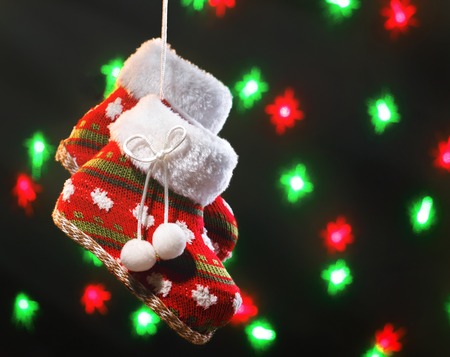 Empty christmas boots on dark background with blurred lightsの写真素材