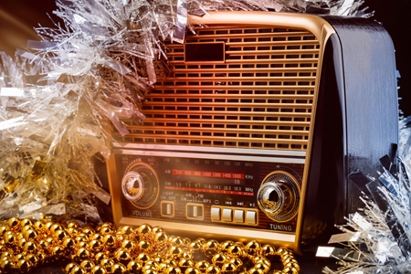 radio receiver in retro style with christmas decorations and light beams on black backgroundの写真素材
