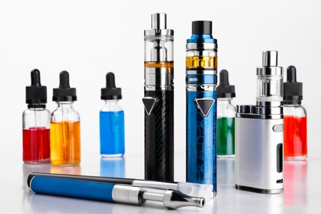 Electronic cigarettes and bottles with vape liquid on white backgroundの写真素材