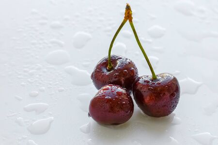 Fresh cherry berries with water drops on white background. Selective focus.