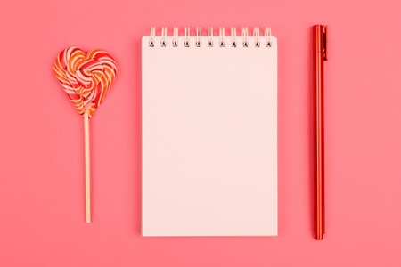 White notepad with red pen and candy-heart.の写真素材
