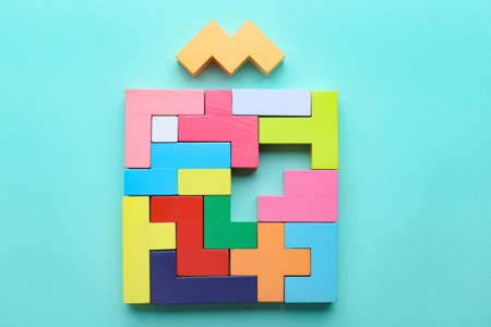 Concept of creative, logical thinking. Different colorful shapes wooden blocks on light background. Geometric shapes in different colors. Child development. Riddle and its solution. Logic tasks.の写真素材