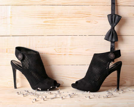 Stylish women's elegant black shoes and a man's bow tie on a light background. Relations he and she, man and woman. Black Friday. party code.の写真素材