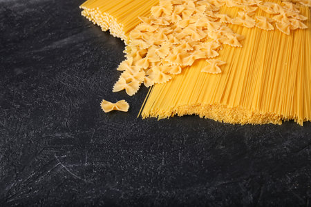 Top view of raw spaghetti on dark background. Uncooked pasta with copy space.の写真素材