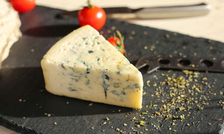 Hard cheese and dorblu cheese on a light wooden surface. Tasty healthy vegan cheeses on the table top viewの写真素材