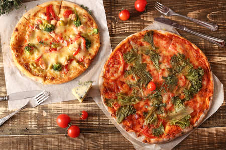Margarita pizza on a dark wooden background, top view. Mazzatzella pizza on a stone board with place for text. Vegan pizza from healthy products top viewの写真素材