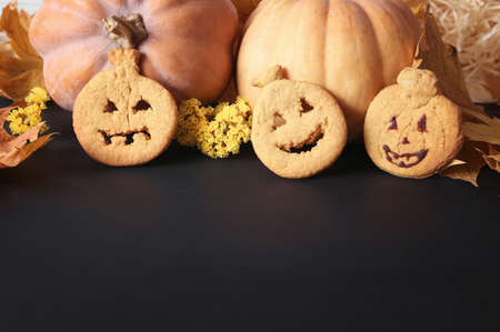 Pumpkin cookies on a black background with place for text. The recipe for fun pastries. Pumpkins and Halloween Cookingの写真素材