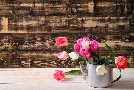 Fresh tulip flowers bouquet in teapot. view with copy space. spring holiday conceptの写真素材