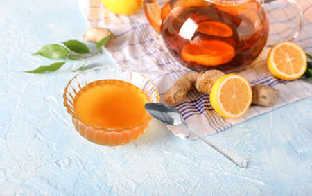 Ginger, half a lemon and honey in a bowl on a burlap top view. Useful vitamin ingredients on a light wooden background.の写真素材