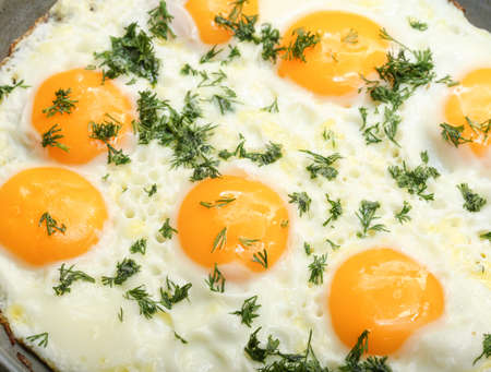 Fresh appetizing fried eggs with greens. Healthy breakfast, cooking eggs. organic product.の写真素材