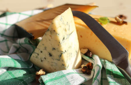 Hard cheese and dorblu cheese on a light wooden surface. Tasty healthy vegan cheeses and nutsの写真素材