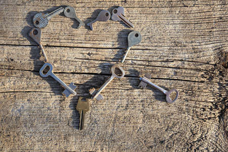 Different old keys on a wooden background close up. Old keys of different shapes on a vintage surface.の写真素材