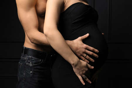 Pregnant woman with her husband. Hands and torso of a pregnant woman and her husband. Expectant parents mom and dad waiting for their baby love conceptの写真素材