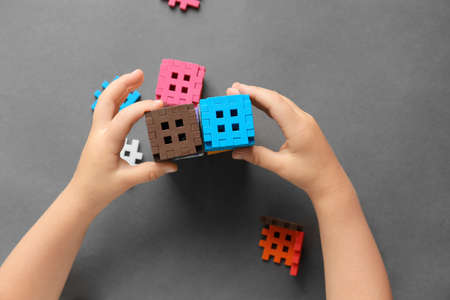 The child builds from a constructor, plays with cubes. Kindergarten. Preschool education, child development concept, color learning. Games for the fine motor skills of the child.の写真素材