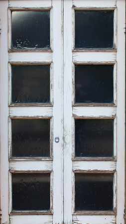 Old wooden doors with glass and peeling white paint.の写真素材