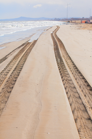Traces of truck on the sand on the beach at the water's edge.の写真素材