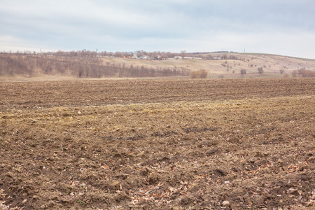 Plowed field with a beautiful panorama and a farm on the horizon.の写真素材