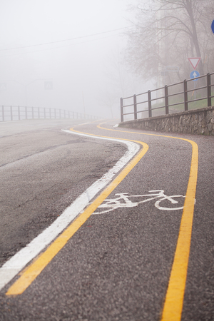 Turn on the road on a foggy overcast day and a bike path.の写真素材