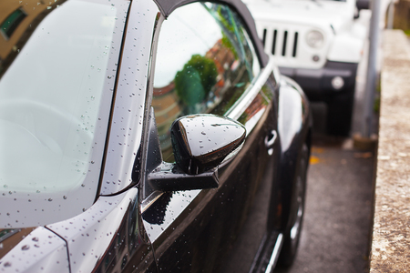 Reflection of the house and raindrops on the lateral side a car parked in a row with the other cars.の写真素材