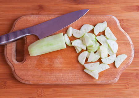 Sliced cucumber and a knife on a cutting board close-up.の写真素材