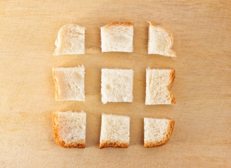photo of slice of bread chopped in pieces on wooden tableの写真素材