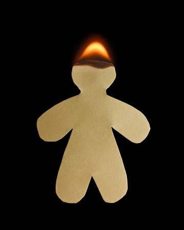Paper man with head burn in flame on black backgroundの写真素材