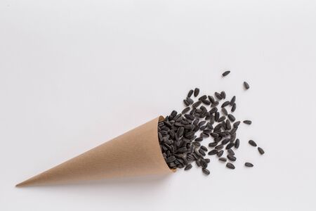 Sunflower seeds in paper cone isolated on white backgroundの写真素材