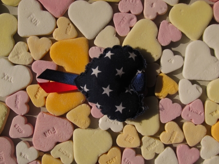 Heartshaped candy hearts with blue and white cotton heart with ribbonsの写真素材