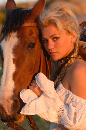 Beautiful blonde peasant with great horse's faceの写真素材