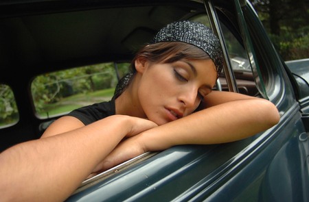 Cute girl sleeping in the car doorの写真素材