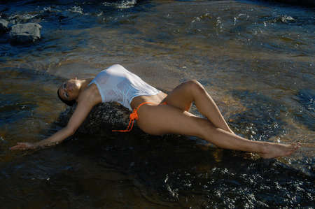 Beautiful brunette girl in the riverの写真素材