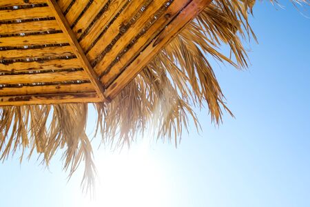 Beach umbrella of bamboo hides from the sunの写真素材