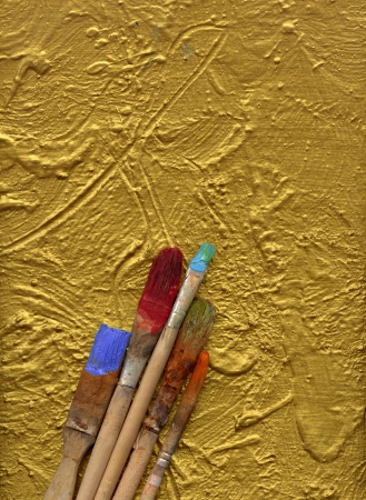 paint brushes lying on gold painted background の写真素材