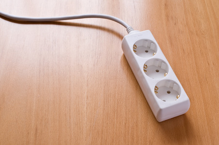 Multiple socket outlet on wooden floor.の写真素材