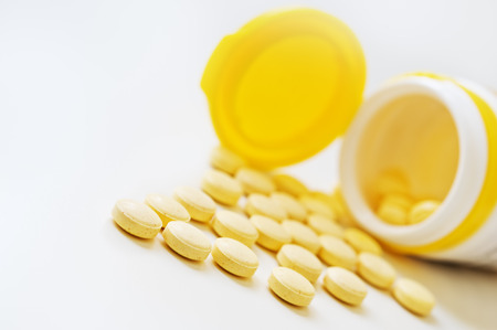 Pills and plastic bottle on the white table.の写真素材